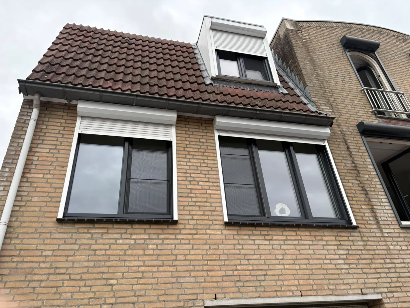 Donkere raamkozijnen in een lichte gemetselde gevel